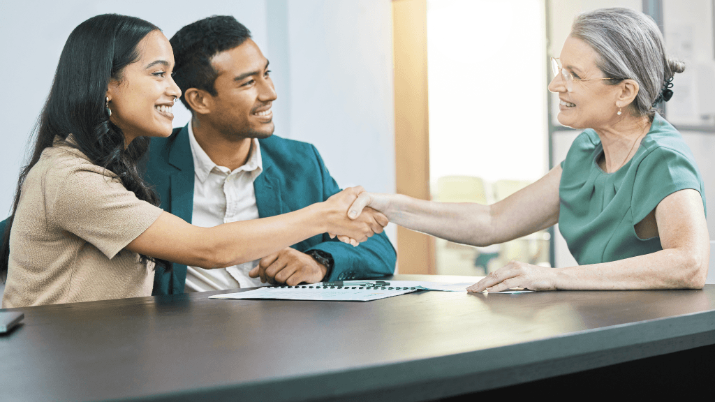 Insurance advisor shaking hands with clients at a consultation meeting