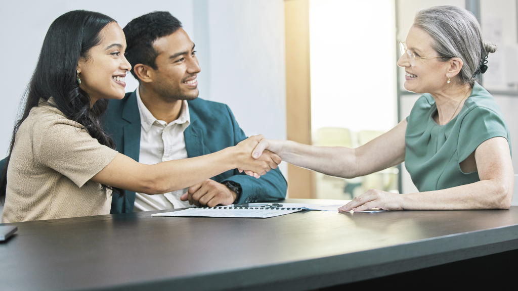 Insurance advisor shaking hands with clients at a consultation meeting